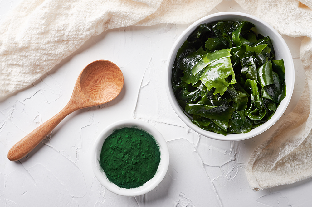 Bowl of green seaweed salad and natural food colouring powder, highlighting organic colouring agents in foods